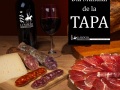 Different spanish embutidos on a table: jamon, chorizo, salami, cheese and a bottle of wine