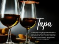 Spanish tapas and sherry aperitif with slices of gourmet ham balancing on top of the glasses with a bowl of bacalao croquettes over a dark background with copy space