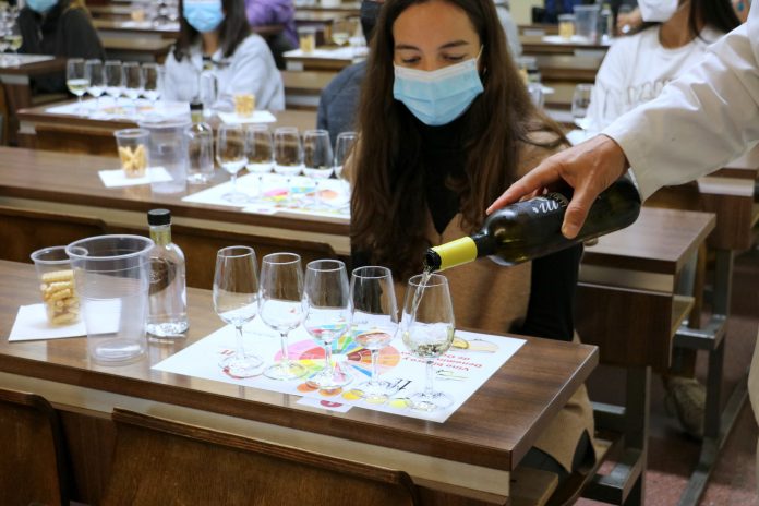 Una joven universitaria cata un vino en León