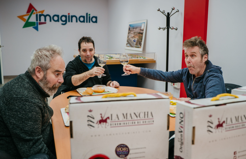 Los 'Gandules' degustan las gachas junto a una copa de vino blanco Airén